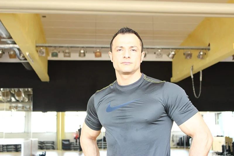 Durchtrainierter Personaltrainer im Studio